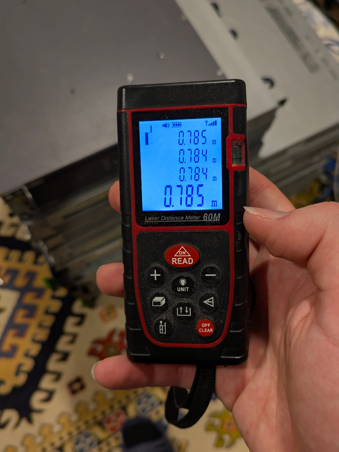 a laser rangefinder showing measurements of the stack height (4 measurements):
- 0.785m
- 0.784m
- 0.784m
- 0.785m a laser rangefinder showing measurements of the stack height (4 measurements):
- 0.785m
- 0.784m
- 0.784m
- 0.785m